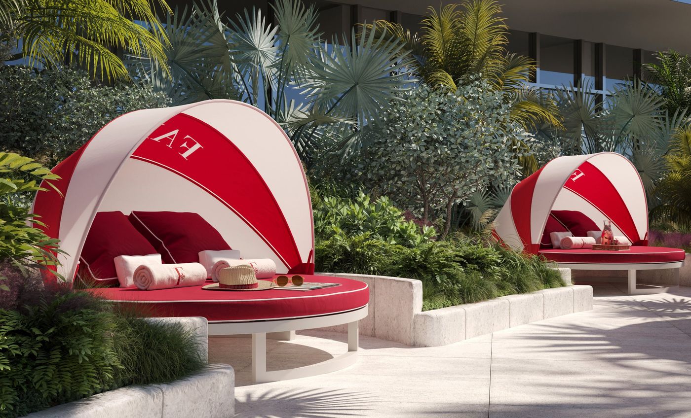 Red and white canopied day beds in tropical planting