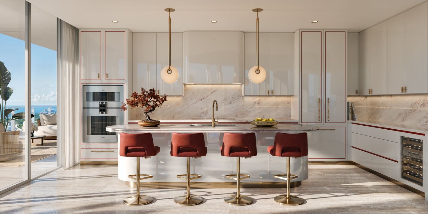 White lacquer kitchen with red-lined cabinetry, marble and brass pendants