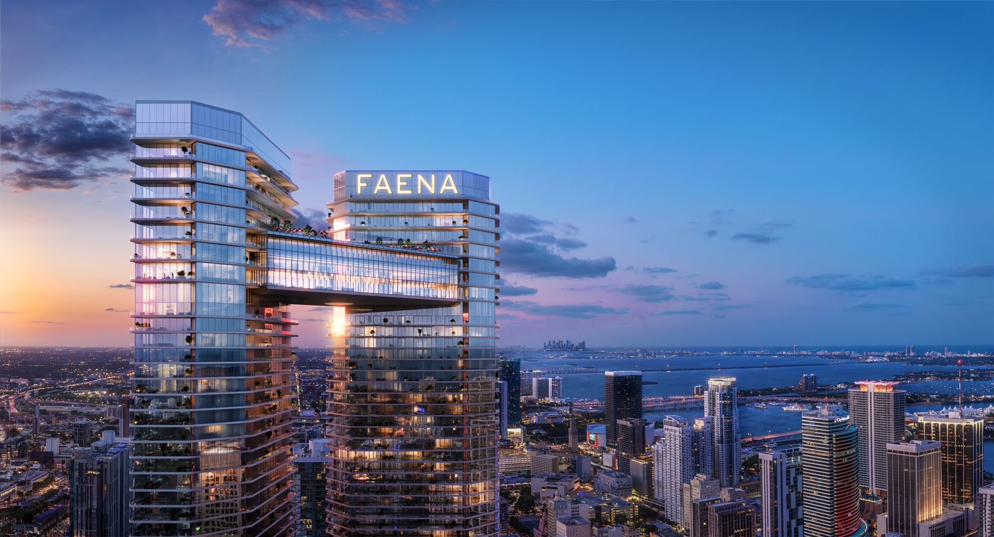 The two towers at dusk joined by the glass Sky Bridge, Biscayne Bay beyond